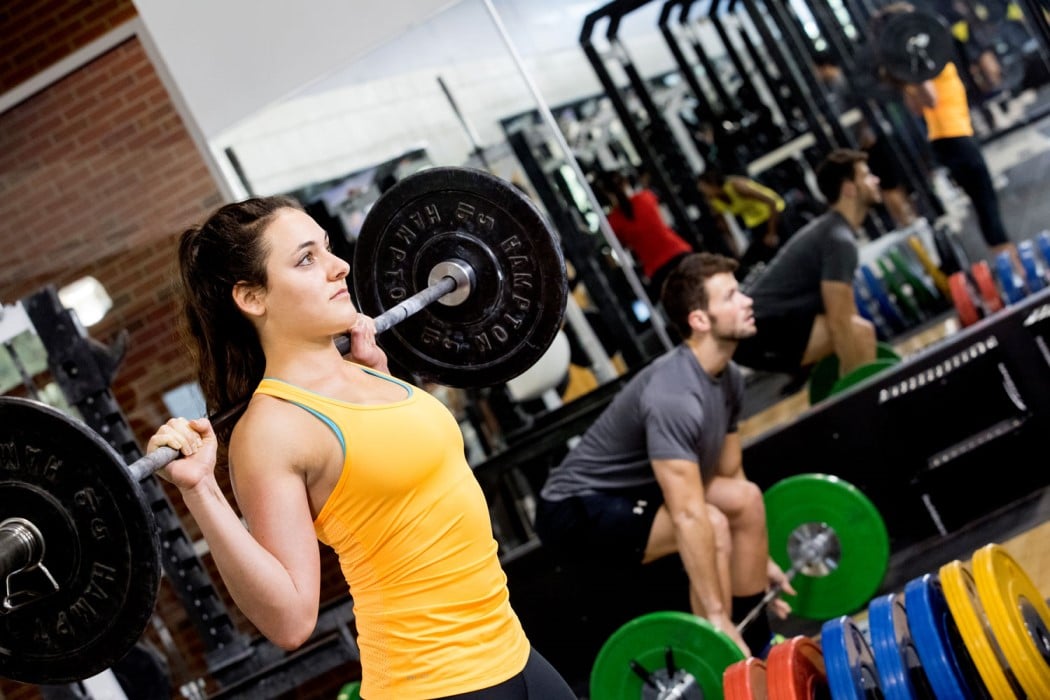A female student lifting free weights at the Southwest Recreation Center on the UF campus