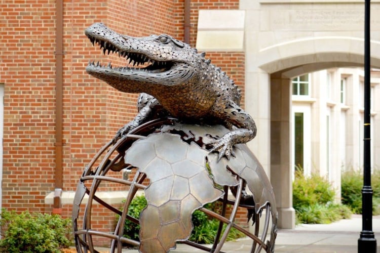 The large bronze Gator Ubiquity sculpture shows a gator on top of the world and located in the courtyard adjacent to Heavener Hall