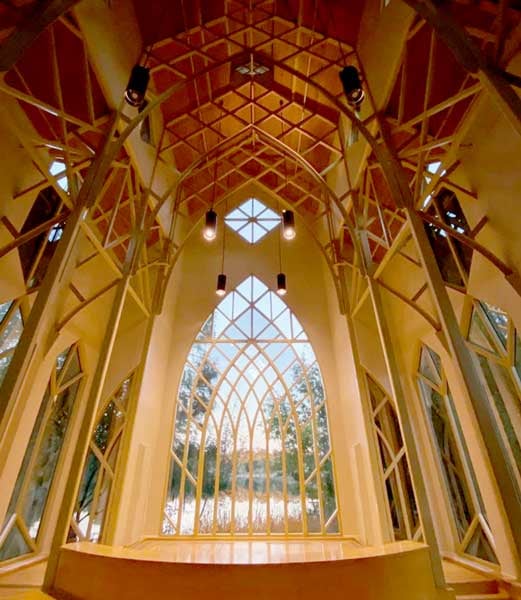 Interior of Baughman Center at dusk showing the lake through the large arched window at the back of the facility