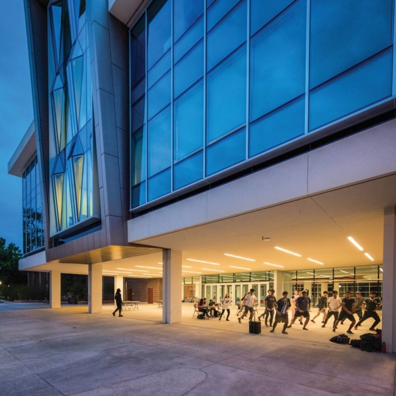 Reitz Union exterior at night with students practicing a dance routine under the large front entrance
