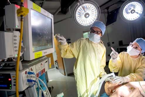 Two student practice incubation on a dummy patient in the Patient Stimulation Unit on the College of Medicine campus