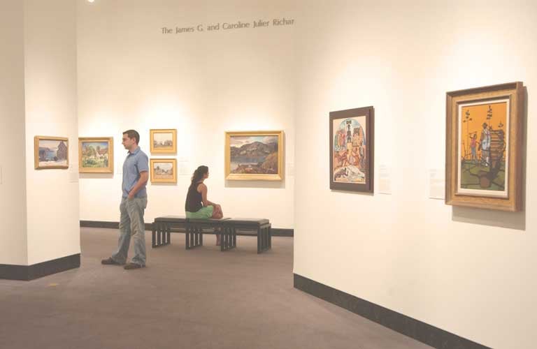 Visitors viewing art exhibited on gallery walls at the Samuel Harn Museum of Art at UF