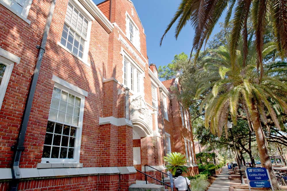 Exterior of Griffin Floyd Hall, shaded by large palm trees>   