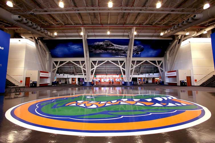 Large lobby of the Exactech Arena at UF, with a large Gatorhead logo on the floor